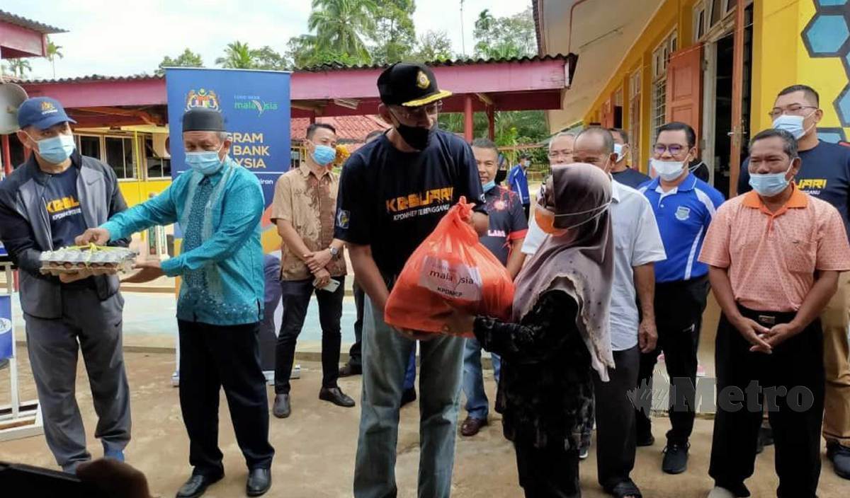ROSOL menyampaikan sumbangan kepada salah seorang mangsa banjir di Sekolah Kebangsaan Lubuk Periok, Hulu Terengganu. FOTO Zatul Iffah Zolkiply