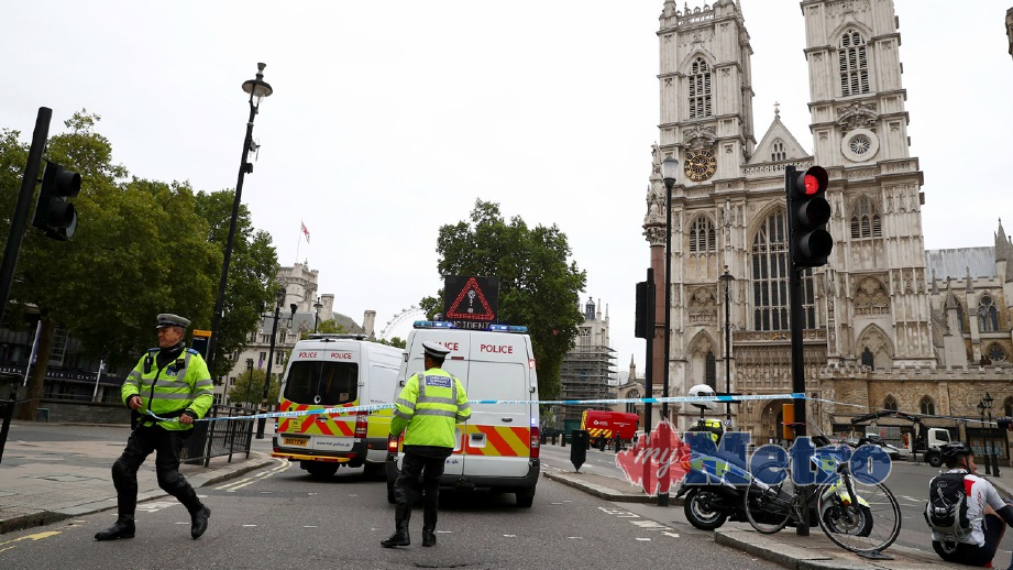 ANGGOTA polis mengawasi lokasi kereta rempuh penghadang di perkarangan bangunan Parlimen Britain di London. FOTO Reuters