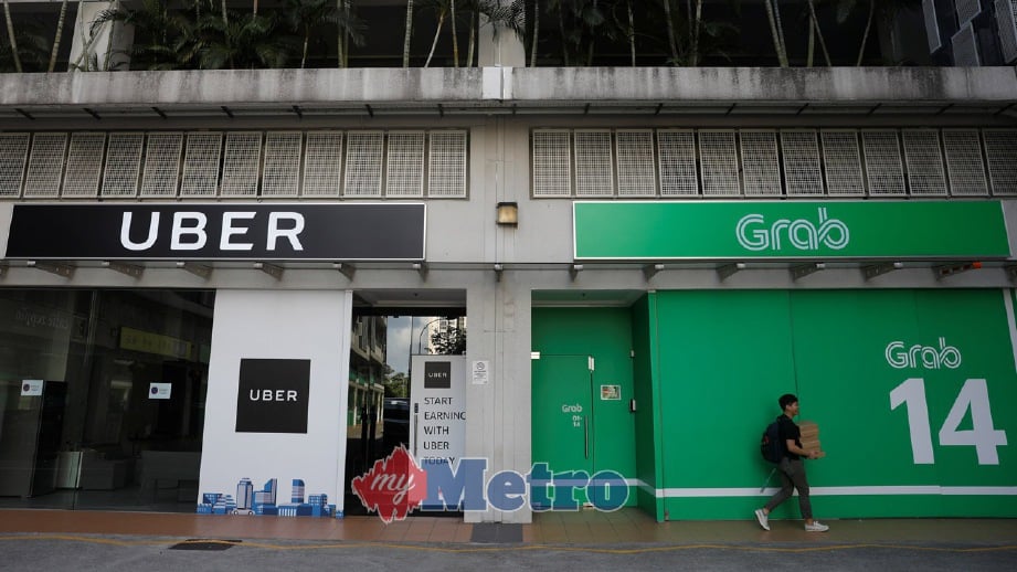PEJABAT Uber dan Grab di Singapura. FOTO Reuters
