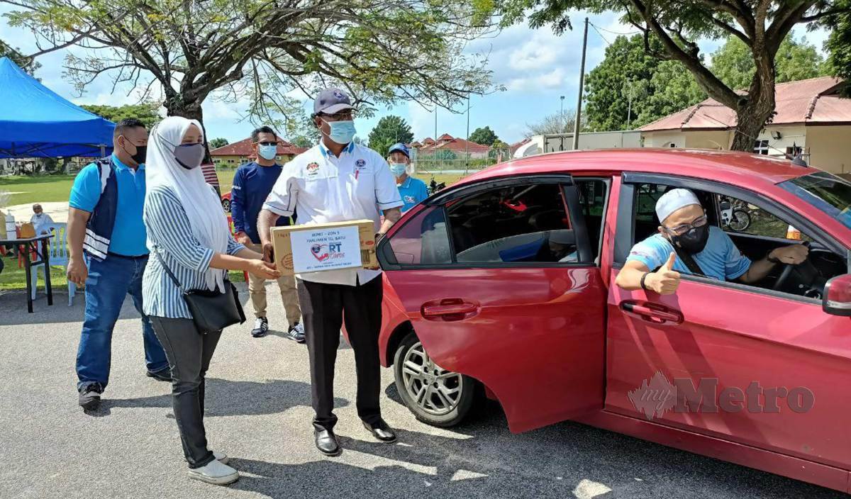 SEBAHAGIAN penerima bakul makanan di RTCare Melaka Tengah di Taman Paya Rumput Indah menerima sumbangan menerusi konsep pandu laju. FOTO Nazri Abu Bakar