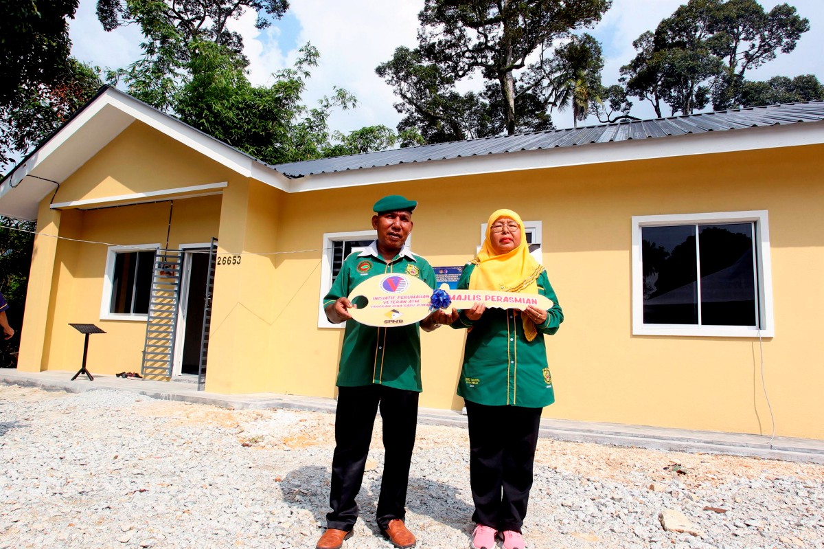Sobri (kanan) dan isterinya Zima Abu Talib, 54, ceria menerima rumah baharu pada Majlis Penyerahan Kunci Rumah Inisiatif Veteran ATM. FOTO Bernama 