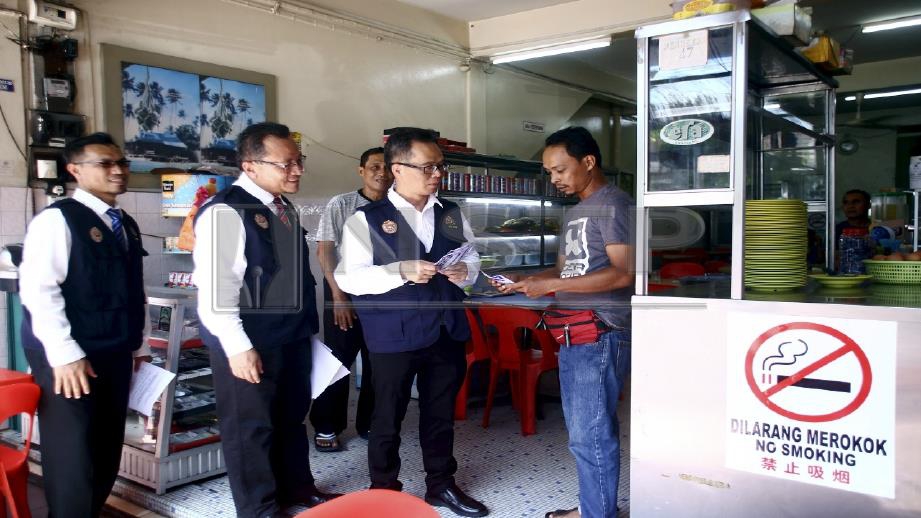 Low Chee Leon (tiga dari kiri) beri penerangan mengenai larangan merokok di gerai makan. STR/ Muhammad Zuhairi Zuber