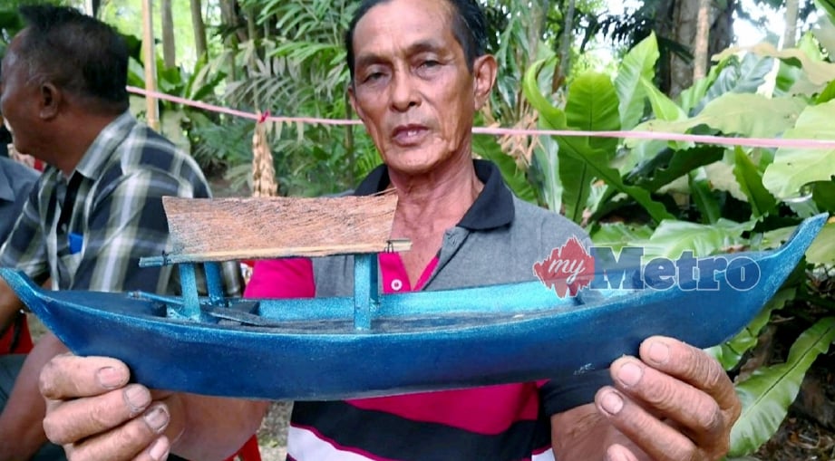MOHAMAD Omar menunjukkan 'bidar' iaitu sejenis bot tradisi bagi masyarakat suku Brunei yang diukir daripada kayu. FOTO Poliana Ronnie Sidom