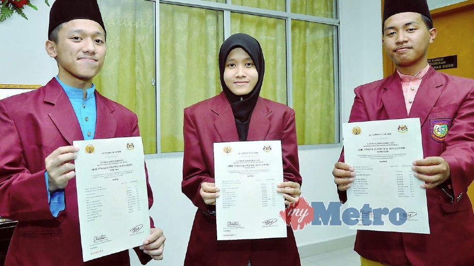 ABDUL Halim Taslim (kiri) bersama Umar Haneef Suharpi (kanan) serta Umairah Abdul Wahab menunjukkan sijil keputusan di Sekolah Menengah Agama Negeri Toh Puan Hajah Rahmah, Kinarut. FOTO Mohd Adam Arinin