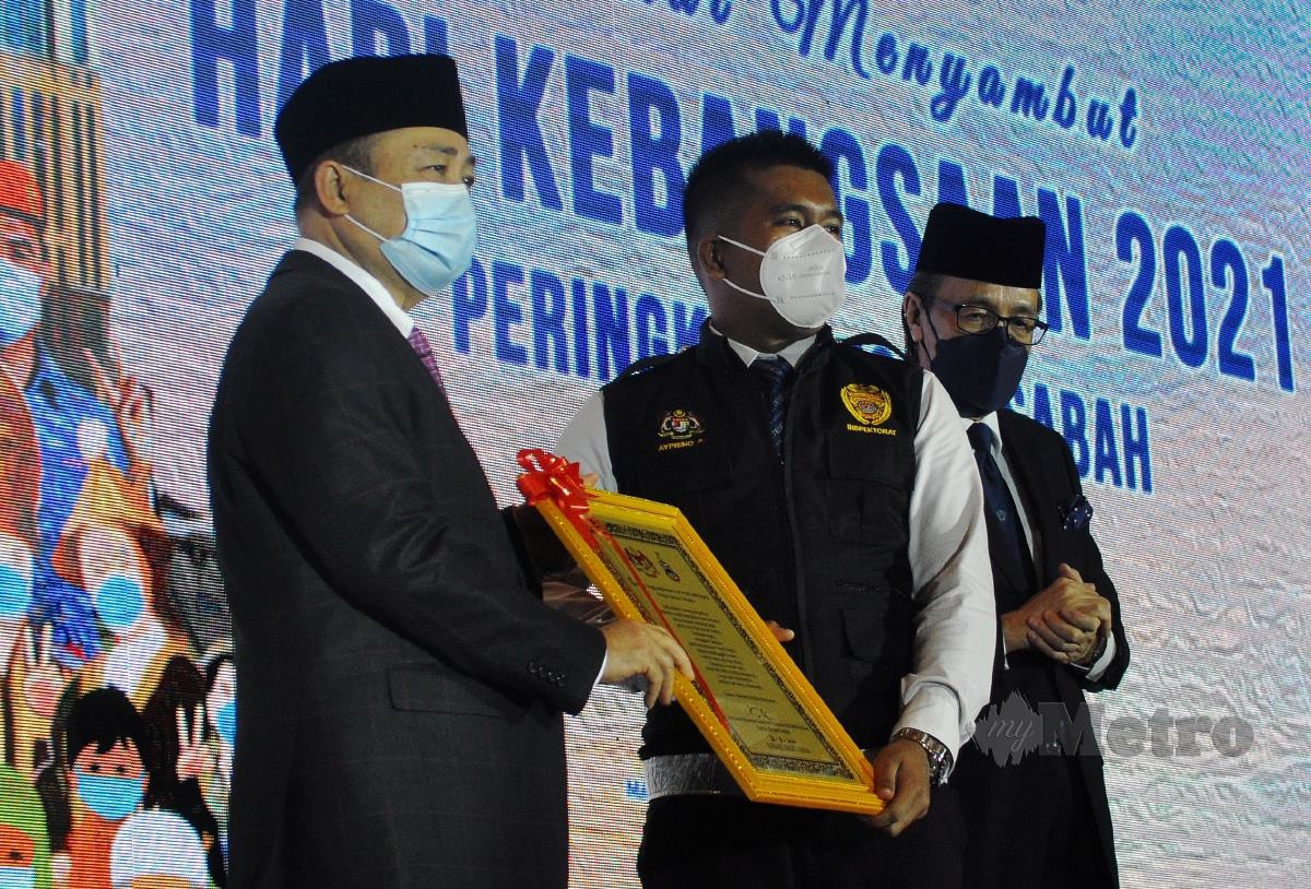 Hajiji Noor (kiri) menyampaikan momento kepada wakil dari Jabatan Kesihatan Negeri Sabah. FOTO MOHD ADAM ARININ
