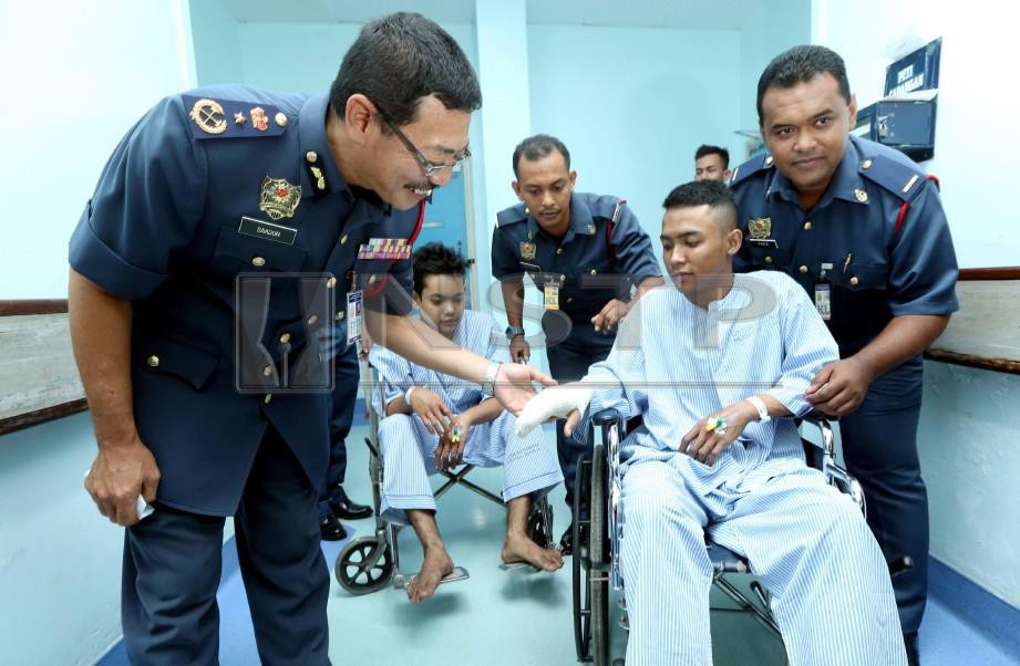 Saadon (kiri) melihat luka salah seorang mangsa, Muhamad Aidil Mat Razali semasa melawat tiga mangsa kebakaran di Hospital Seberang Jaya. FOTO Rosli Ahmad