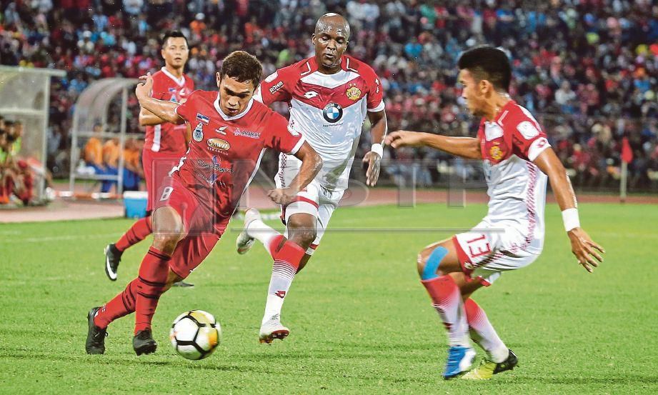 PEMAIN Sabah, Mohd Azzizan Nordin (kiri) cuba melepasi pertahanan Kelantan dalam perlawanan bola sepak suku akhir kedua Piala Malaysia 2018 di Stadium Likas. FOTO Khairull Azry Bidin