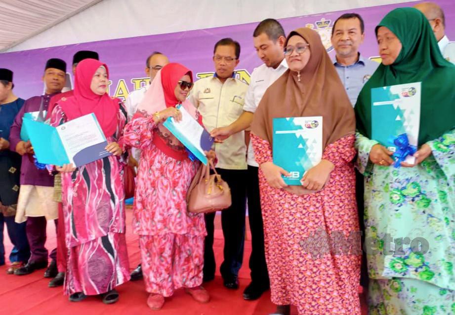 DR SAHRUDDIN (tengah) beramah mesra dengan penerima sijil Notis 5A. FOTO Mohd Sabran Md Sani