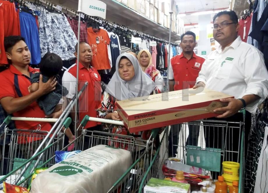 MAS Imran (kanan) menyerahkan sumbangan kepada Salmah di Pasaraya Econsave Kulai, hari ini. Foto MARY VICTORIA DASS
