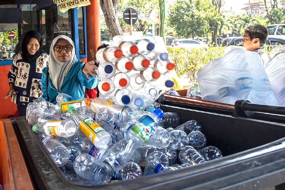 ORANG awam membawa botol plastik yang boleh ditukarkan kepada tiket bas Suroboyo di terminal bas Surabaya, Indonesia. FOTO AFP