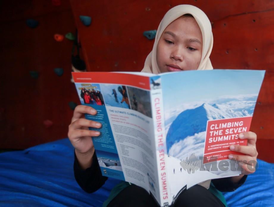 SARA Sofea membaca buku mengenai pendakian tujuh benua. FOTO Sairien Nafis