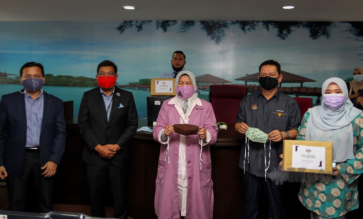Zuraida Kamaruddin (tengah) menunjukkan pelitup muka yang akan diberi kepada wakil KePT pada lawatan kerja Menteri Perumahan Dan Kerajaan Tempatan di MPPD. FOTO AZRUL EDHAM MOHD AMINUDDIN