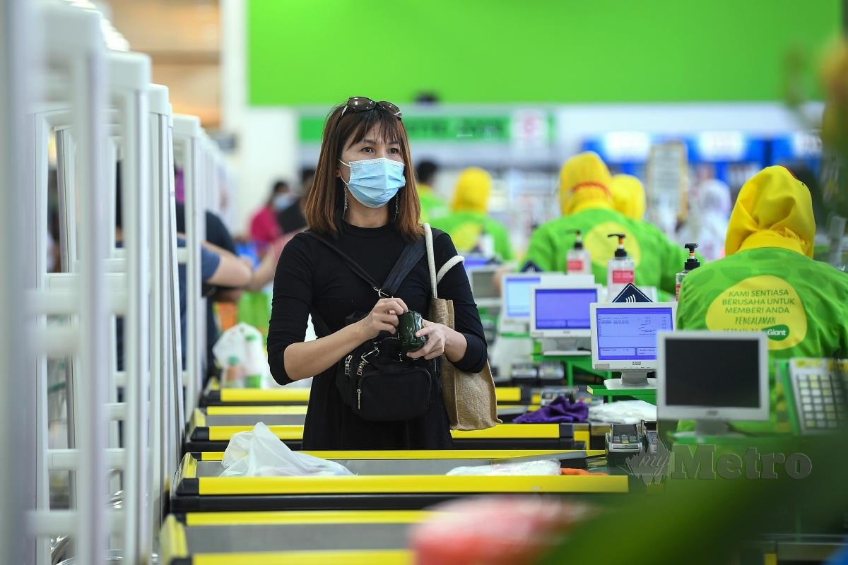 Orang awam mematuhi (SOP) dengan memakai pelitup muka dan menjaga jarak di dalam sebuah pasar raya.