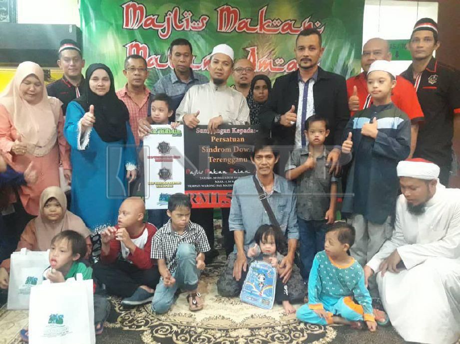 Hasanulddin (tengah) dan Che Mohd Ibrahim (tiga kanan) bersama anak-anak sindrown down PSDT ceria menerima sumbangan daripada Warisan. FOTO Ahmad Rabiul Zulkifli 