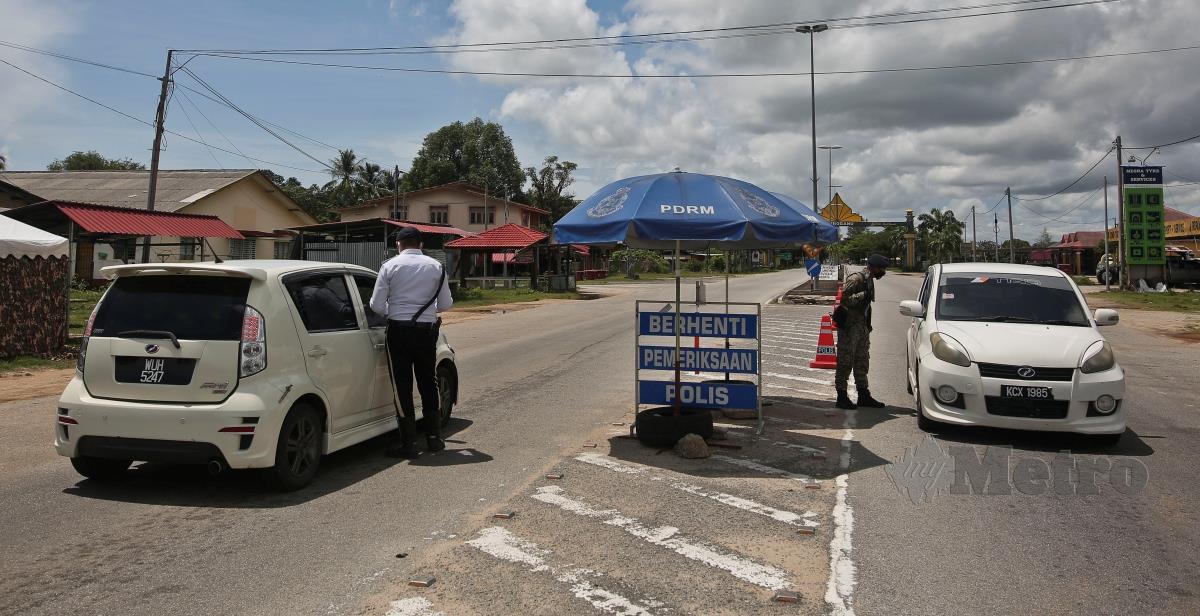 ANGGOTA polis dan tentera memeriksa dokumen perjalanan pemandu ketika Sekatan Jalan Raya (SJR) di Kampung Pachakan di sempadan Terengganu-Kelantan ketika PKP dilaksanakan di daerah Besut. FOTO GHAZALI KORI