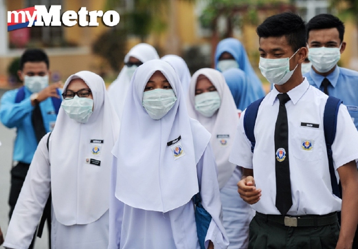 Pelajar diarah memakai topeng ketika keluar selepas tamat sesi sekolah Sekolah Menengah Kebangsaan Seri Ampang, Kuala Kedah, hari ini. - Foto BERNAMA