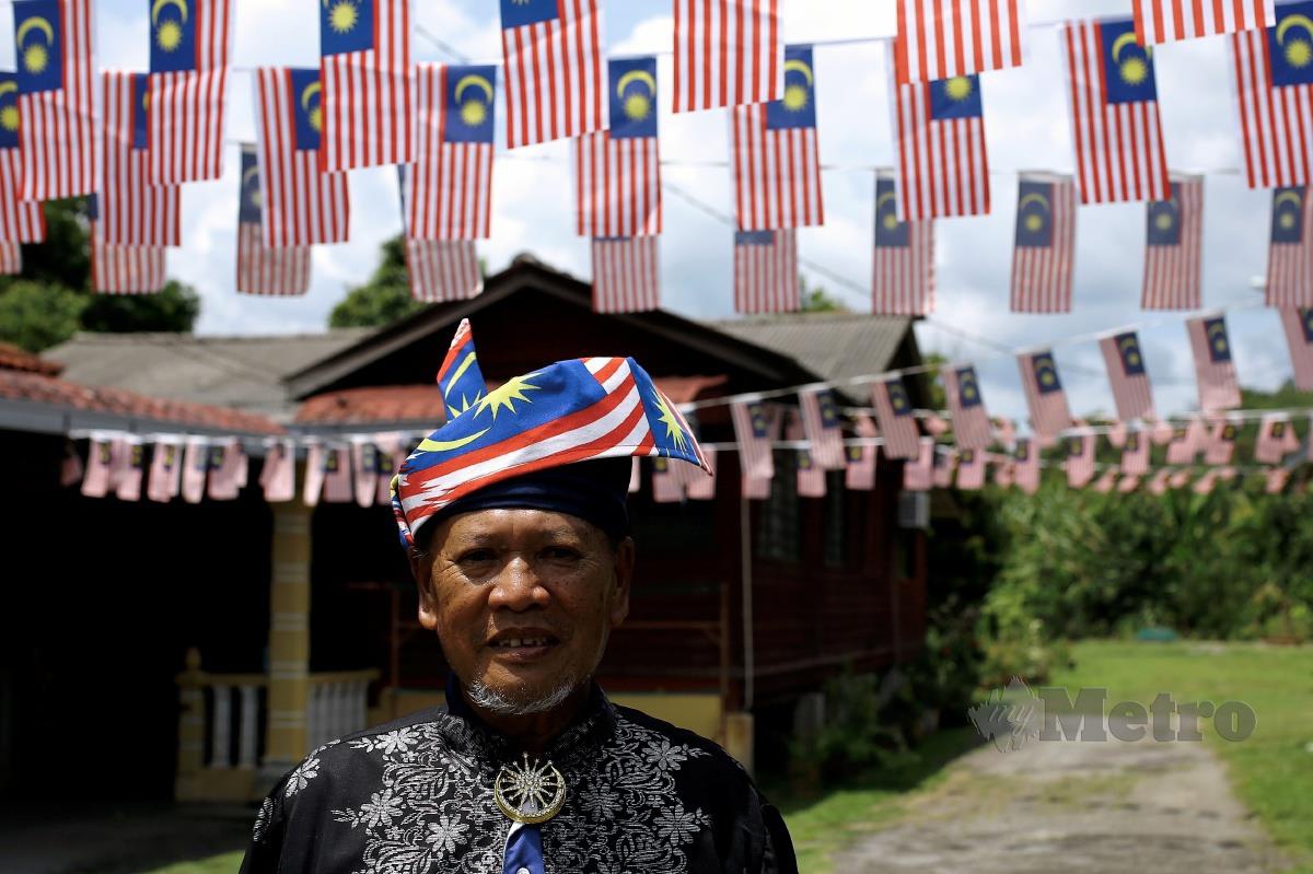 LATIF memakai tanjak bendera Malaysia di hadapan  rumahnya yang turut dihiasi  Jalur Gemilang. 