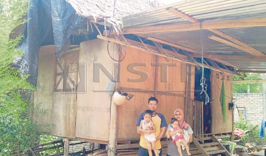 MOHAMAD Shuid bersama isteri serta dua anak dihadapan pondok didiami mereka di Kampung Seniyek, Kupang, Baling. FOTO Safuri Kamarudin.