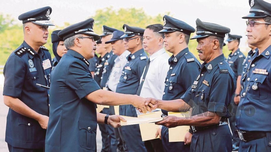 SHARUL Lalli (dua dari kiri) menyampaikan sijil penghargaan kepada Koperal Hamidi Daud (dua dari kanan) pada Perhimpunan Bulanan IPK Melaka di Bukit Beruang. FOTO Rasul Azli Samad