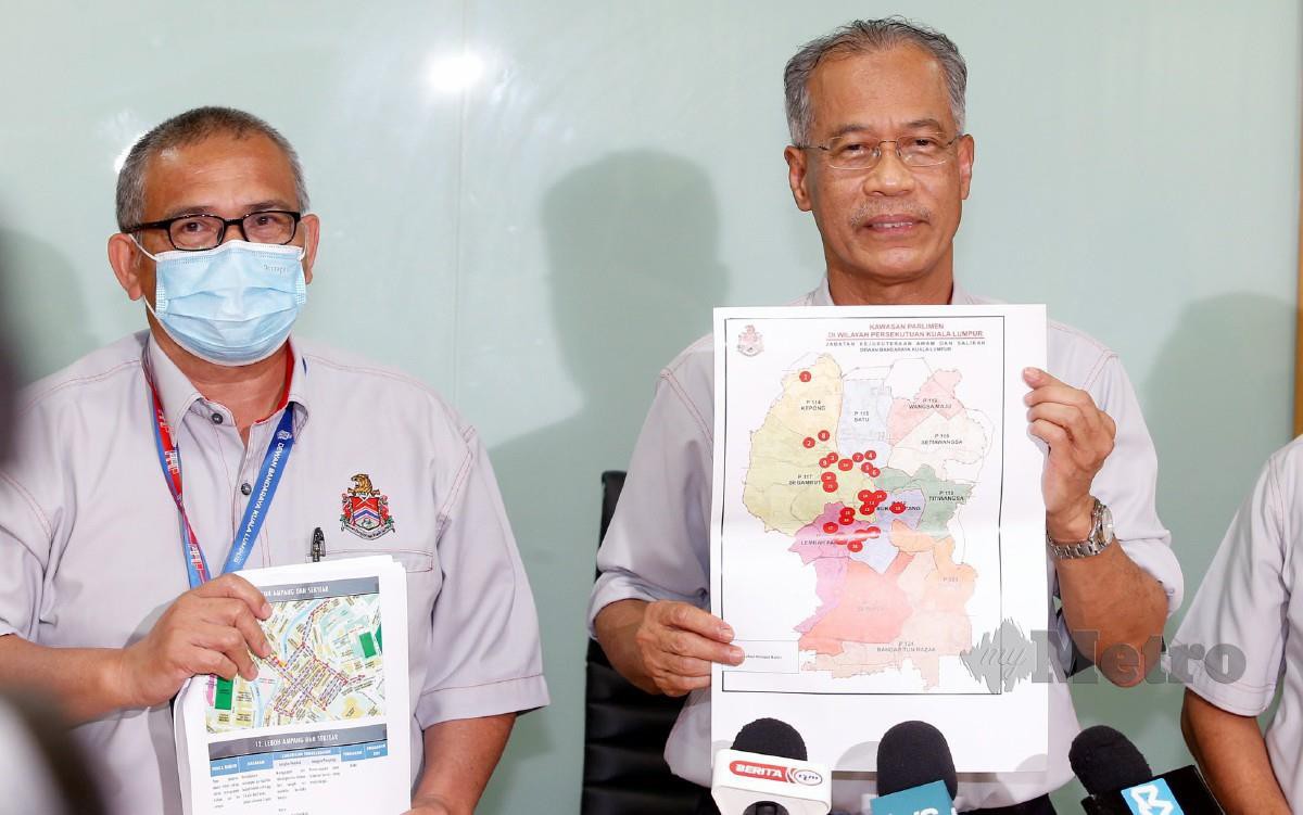 Mahadi (tengah) menunjukkan pelan tindakan ketika sidang media Pelan Tindakan Kawalan Banjir Kilat di Menara DBKL, Kuala Lumpur.FOTO HAIRUL ANUAR RAHIM