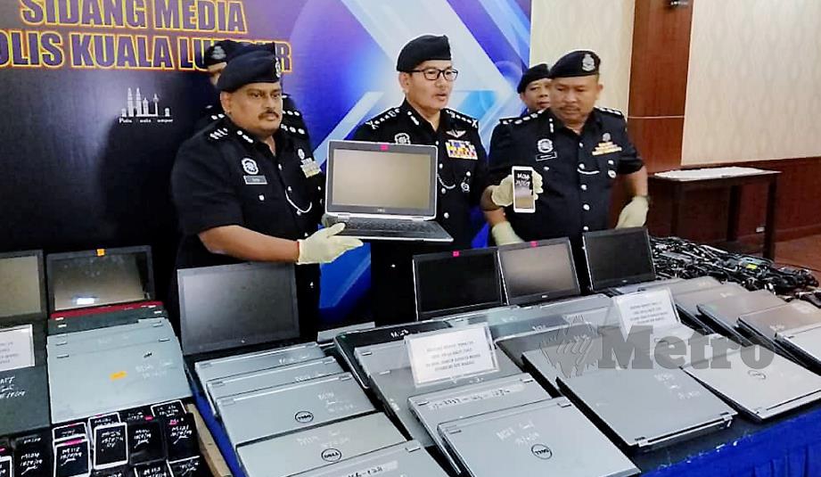 MAZLAN (tengah) bersama pegawainya menunjukkan set komputer riba pelbagai jenama dirampas daripada sindiket judi dalam talian pada sidang media di IPK Kuala Lumpur, hari ini. 