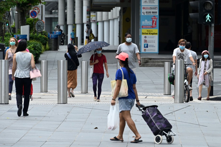 ORANG awam memakai pelitup muka di kawasan beli-belah di Orchard Road, SIngapura. FOTO AFP