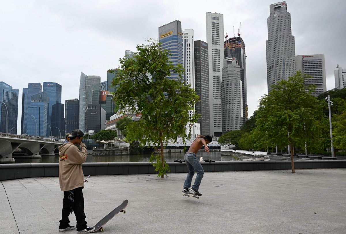REMAJA bermain papan selaju di Singapura. FOTO AFP
