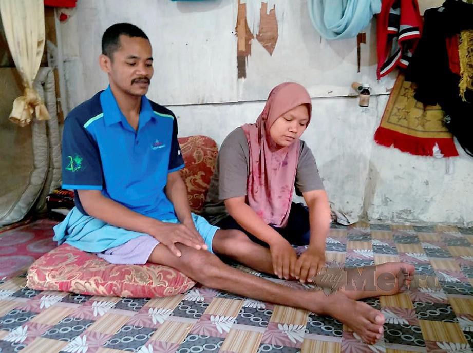 Siti Juriah menemani Muhammad Zailani yang lumpuh di Kampung Limau Kasturi. FOTO Ramli Ibrahim