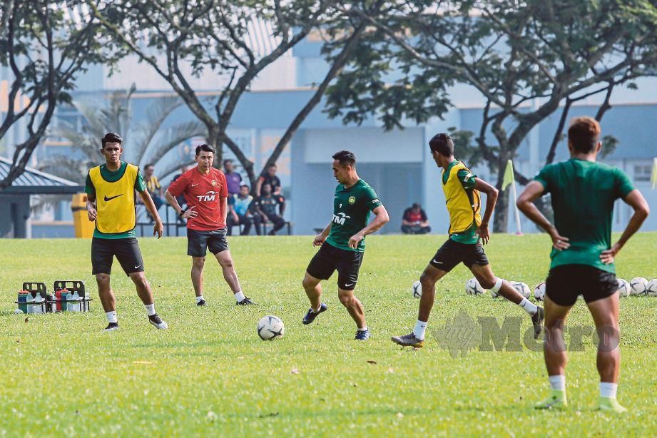 TAN Cheng Hoe (dua dari kiri) memantau latihan pemain skuad bola sepak Malaysia.