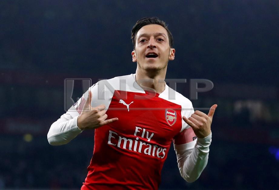  Pemain Arsenal Mesut Ozil meraikan jaringannya ketika Arsenal menewaskan Bournemouth 5-1. FOTO Reuters.