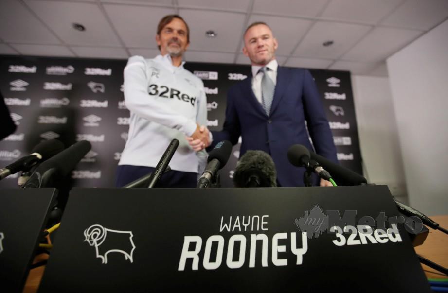Rooney (kanan) bersalaman tangan dengan pengurus Derby County Phillip Cocu. FOTO Reuters