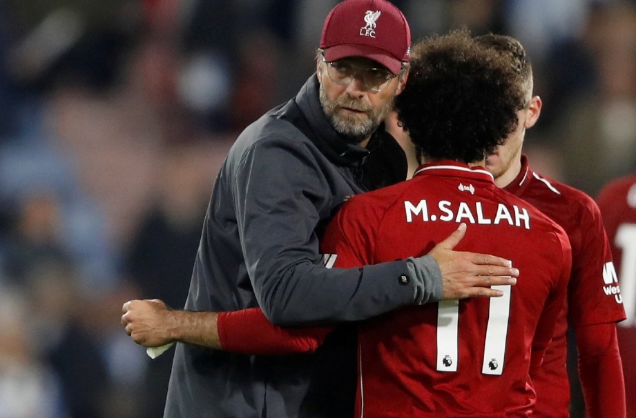 PENGURUS Liverpool, Juergen Klopp memeluk Mohamed Salah selepas perlawanan menentang Huddersfield. FOTO Reuters