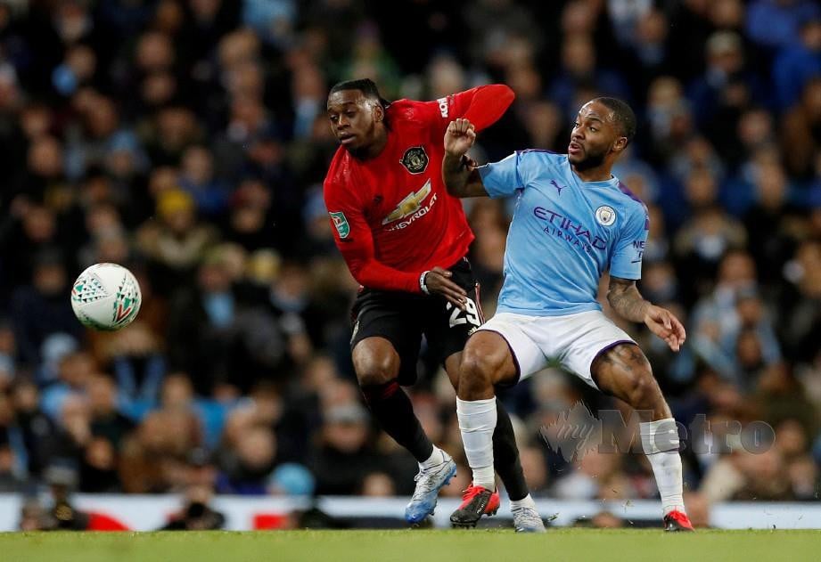 Pemain Manchester United, Aaron Wan-Bissaka bersaing merebut bola dengan pemain City, Raheem Sterling pada saingan Piala Liga. FOTO Reuters