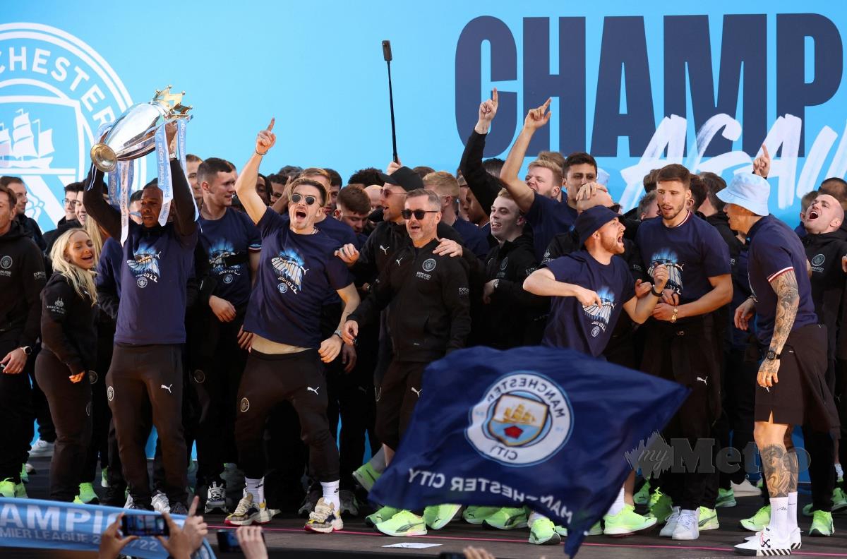 PEMAIN Manchester City berarak dengan trofi bagi meraikan kejayaan mempertahankan gelaran Liga Perdana Inggeris. FOTO REUTERS 