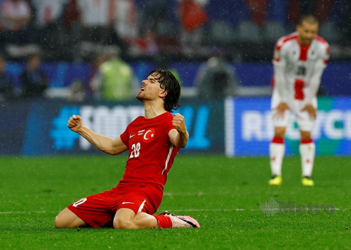 Pemain Turkiye Ferdi Kadioglu celebrates meraikan gol ketiga pasukannya yang dijaringkan  Kerem Akturkoglu. - Reute
