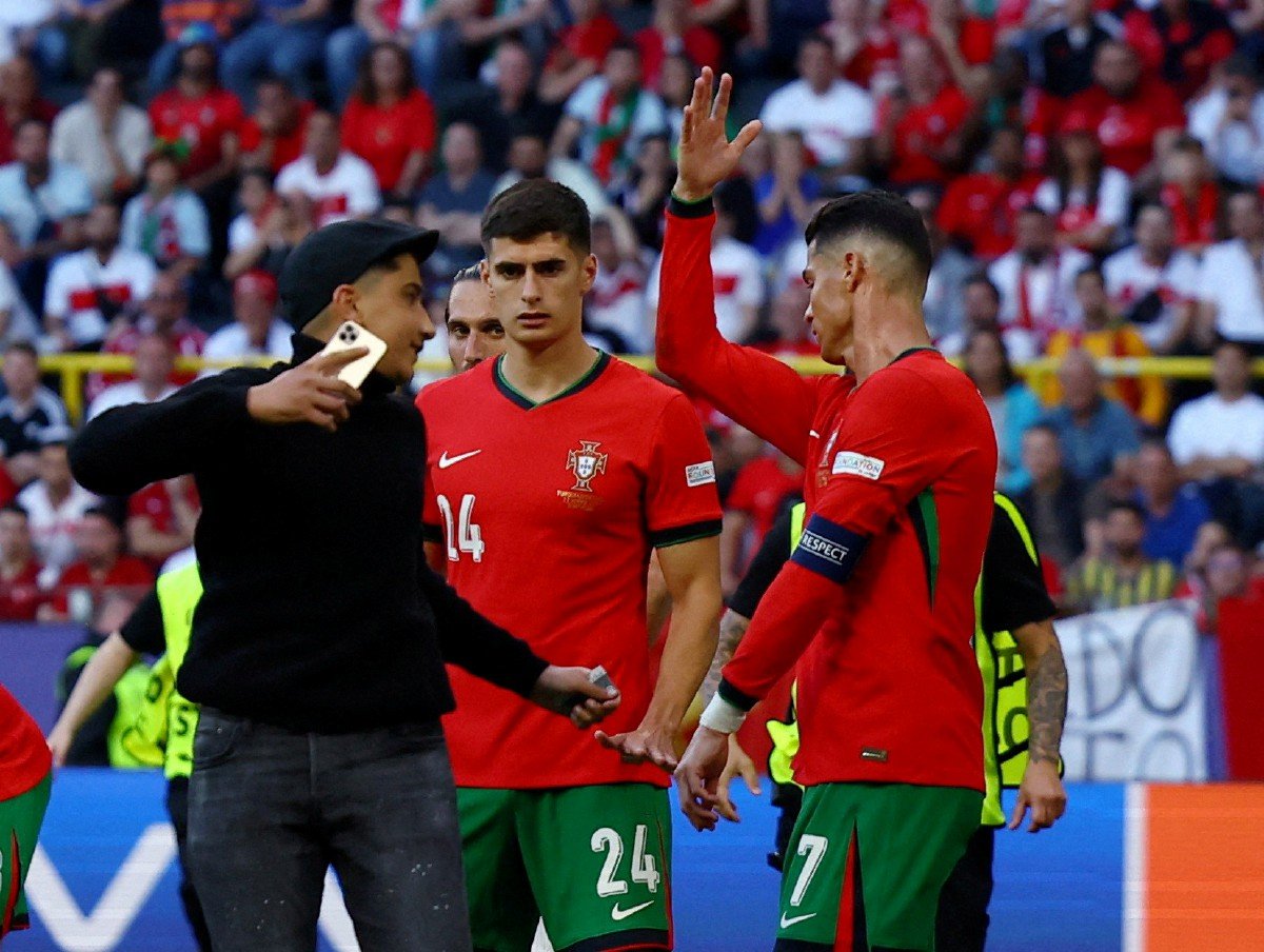 SEKURANG-KURANGNYA lima penonton berjaya memasuki padang ketika perlawanan Portugal bertemu Turkiye. -FOTO Reuters 