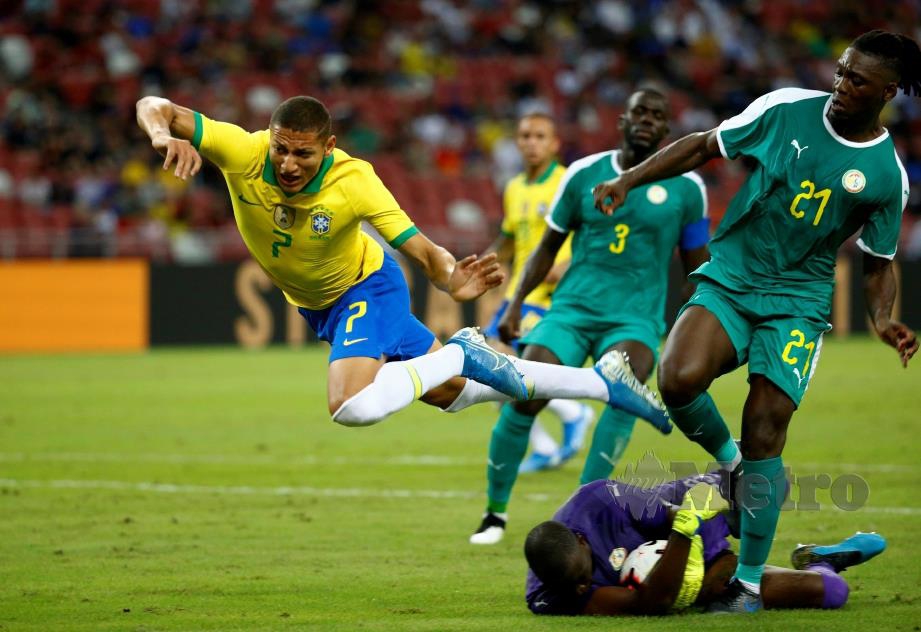 PENJAGA gol Senegal, Alfred Gomis menyelamatkan gawangnya daripada ditembusi  Richarlison.  - FOTO Reuters 