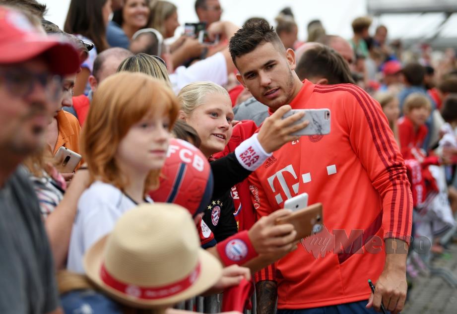 HERNANDEZ melayan kerenah peminat ketika rehat sesi latihan Bayern di  Munich. - FOTO Reuters