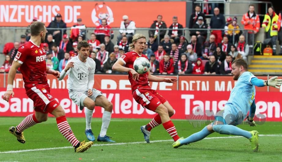 PEMAIN Bayern,  Thomas Muller melakukan percubaan yang cuba diselamatkan penjaga gol  Cologne,  Timo Horn di RheinEnergieStadion, Berlin. FOTO 
