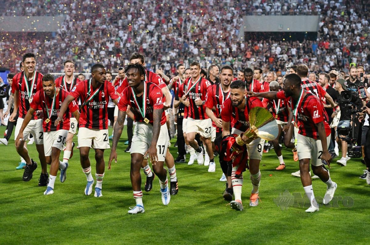 PENYERANG AC Milan, Olivier Giroud memegang trofi dan meraikan kejayaan muncul juara Serie A bersama rakan sepasukan. FOTO REUTERS