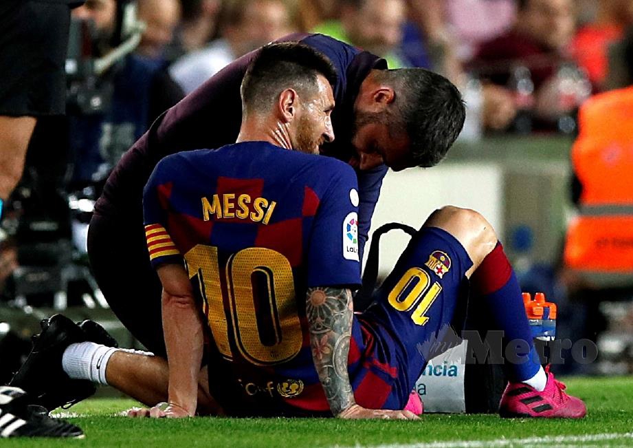 MESSI menerima rawatan ketika menentang Villarreal.  - FOTO Reuters