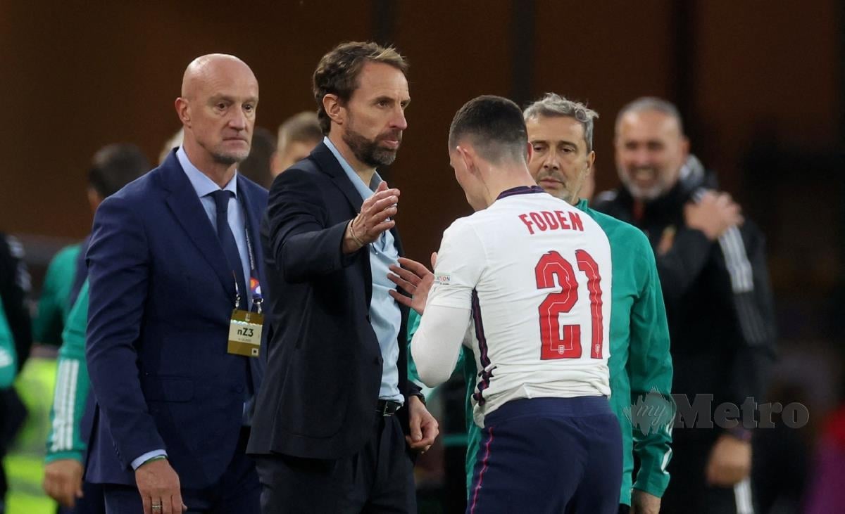 PENGURUS England, Gareth Southgate (tengah) dan Phil Foden kelihatan kecewa selepas kekalahan England, awal pagi tadi. FOTO REUTERS 