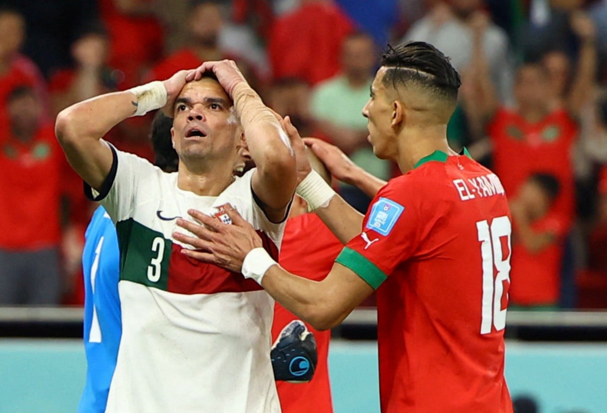 Reaksi pertahanan Portugal, Pepe yang terlepas peluang menjaringkan gol sambil diperhatikan pemain Maghribi, Jawad El Yamiq. FOTO Reuters
