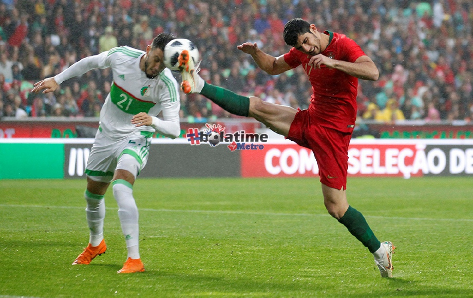 GUEDES (kanan) merampas bola daripadapemain Algeria Ramy Bensebaini. FOTO/REUTERS