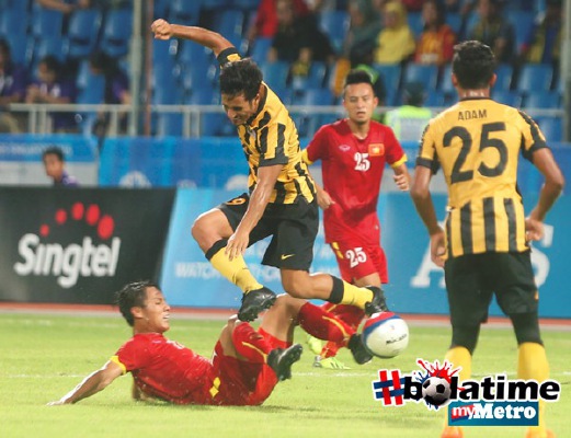 PEMAIN Malaysia, Matthew Thomas (tengah) diasak pemain Vietnam, Ho Ngoc Thang (kiri). FOTO Hairul Anuar Abd Rahim
