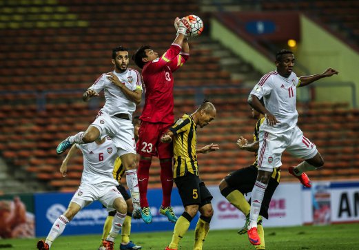 PENJAGA Gol Malaysia, IzhamTarmizi (tengah) menangkis cubaan pemain UAE, Ali Ahmed Mabkhout (kiri) dan Ahmed Khalil (kanan). FOTO Osman Adnan