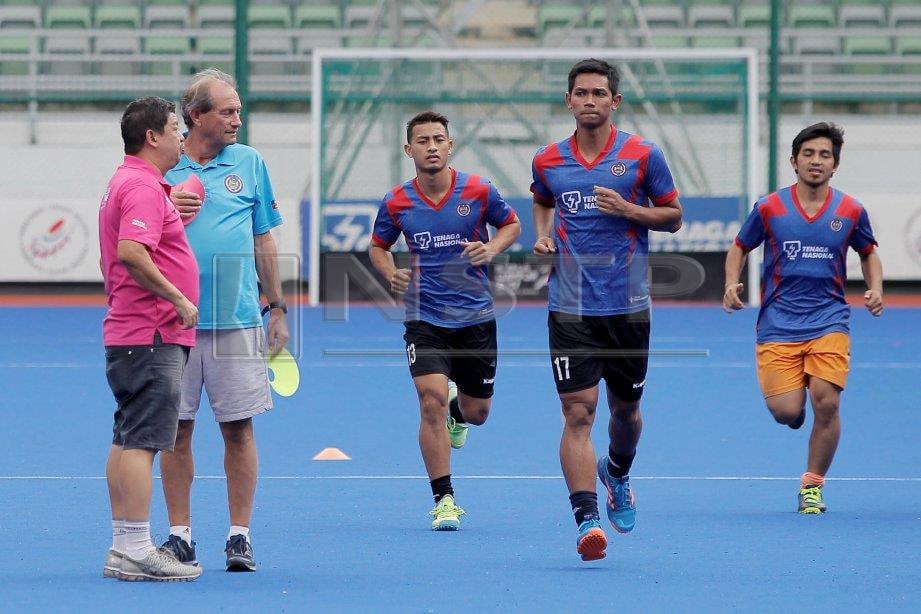 OLTMANS (dua kanan) bersama Van Huizen memerhati pemain hoki kebangsaan memulakan latihan memanaskan di Stadium Hoki Bukit Jalil, Kuala Lumpur. FOTO Aizuddin Saad