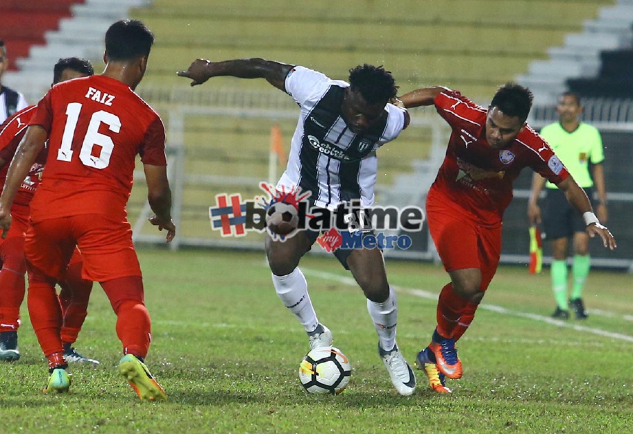SUNDAY Wasiu (tengah) diasak pemain UiTM FC pada aksi Liga Perdana 2018 di Stadium Sultan Ismail Nasiruddin Shah.  -Foto ROZAINAH ZAKARIA