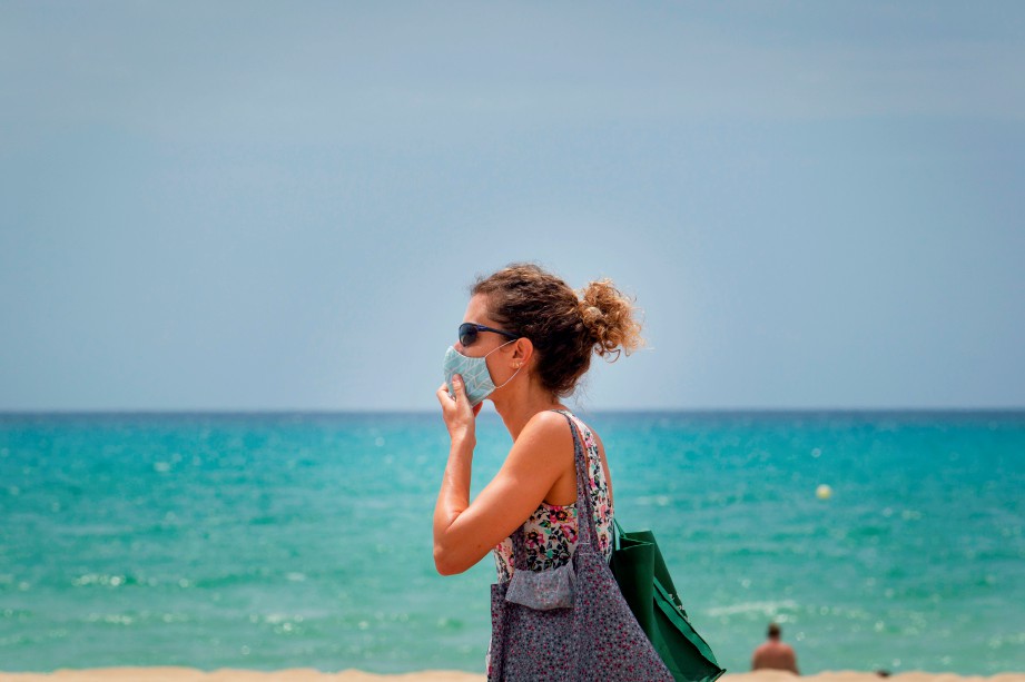 WANITA memakai pelitup muka di Pantai Palma, Palma de Mallorca, Pulau Majorca di Sepanyol. FOTO AFP 
