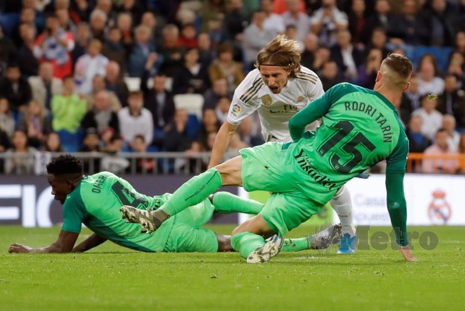 DUA pemain Leganes menyekat kemaraan pemain tengah Real Madrid,  Luka Modric (tengah). - FOTO EPA